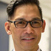 Man in glasses smiling.