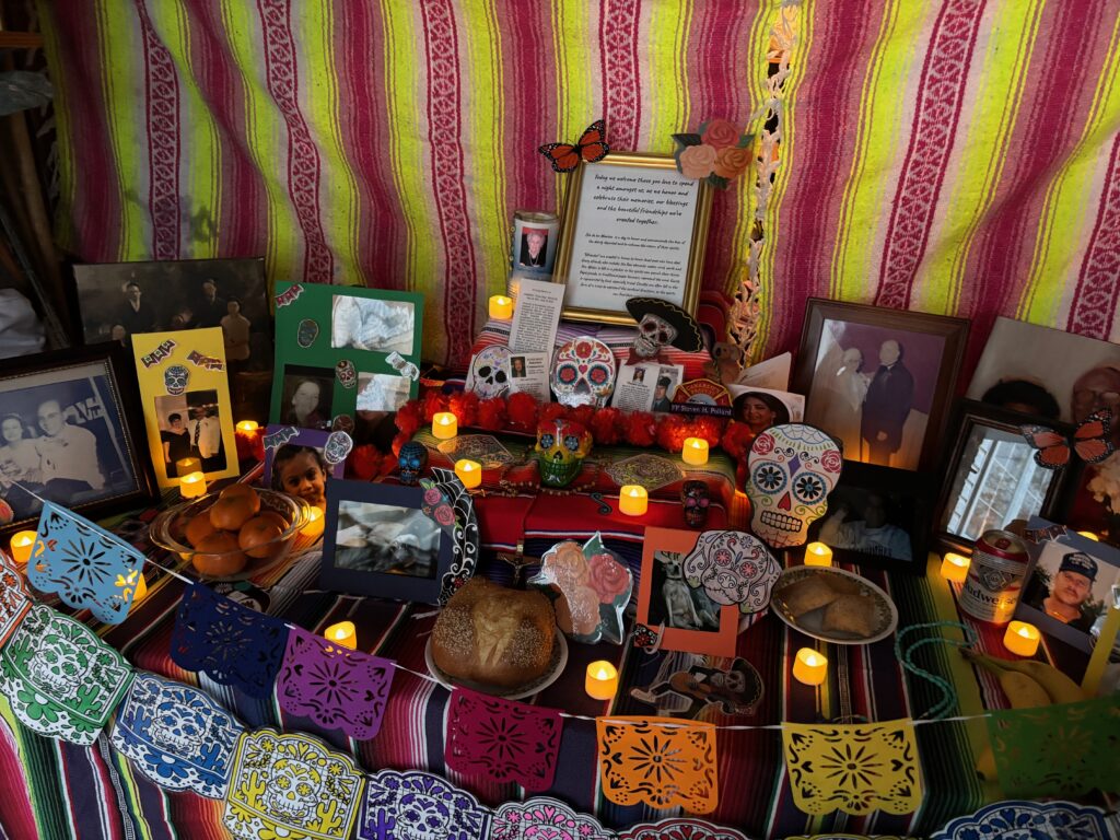 A colorful ofrenda (altar) decorated with candles, marigolds, and framed photos honoring loved ones lost, symbolizing how grief can inspire strength in the fight against C. diff.